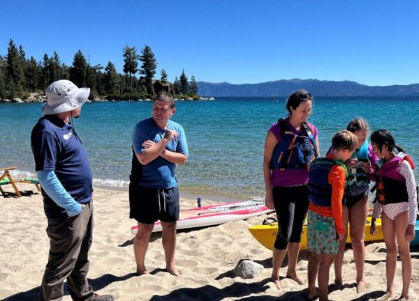 Roving inspector talks with a family of kayakers at Meeks Bay